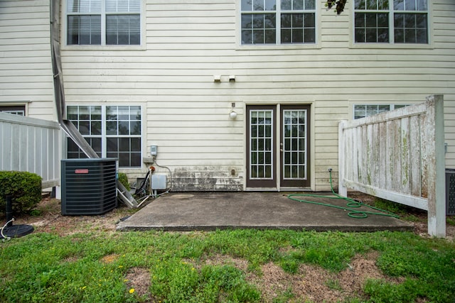 rear view of house featuring central AC unit, fence, and a patio area