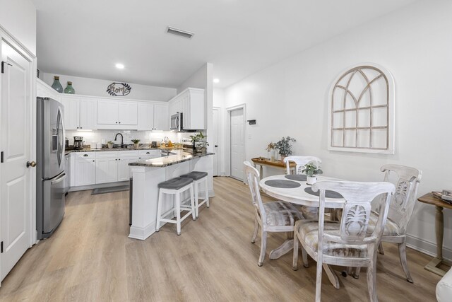25 S Wildflower Dr Unit 224, Santa Rosa Beach, FL 32459 - kitchen with white cabinets, visible vents, a peninsula, stainless steel appliances, and light wood-style floors