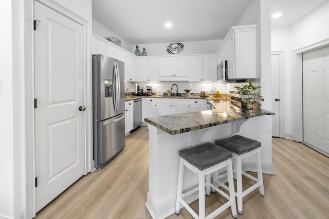25 S Wildflower Dr Unit 224, Santa Rosa Beach, FL 32459 - kitchen with dark stone countertops, light wood-style floors, appliances with stainless steel finishes, and a peninsula