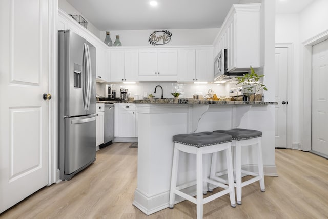 25 S Wildflower Dr Unit 224, Santa Rosa Beach, FL 32459 - kitchen with light wood finished floors, dark stone counters, tasteful backsplash, and appliances with stainless steel finishes