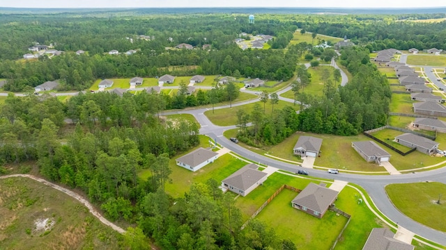 drone / aerial view featuring a forest view and a residential view