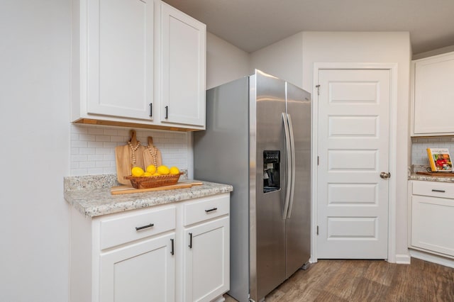 kitchen featuring stainless steel fridge, decorative backsplash, white cabinetry, and wood finished floors
