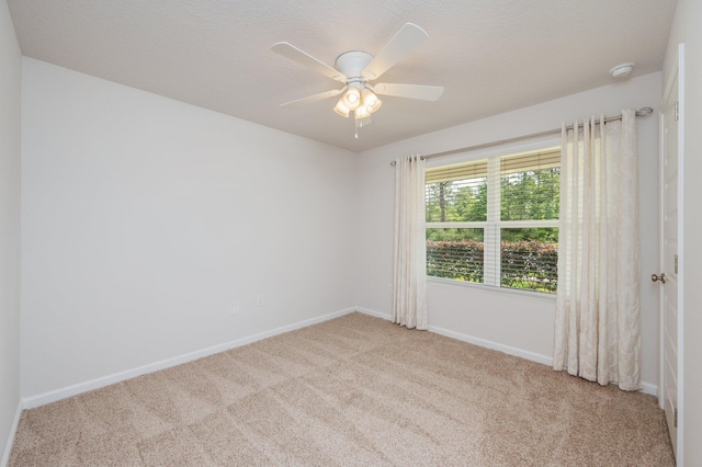 unfurnished room with carpet floors, baseboards, and a ceiling fan