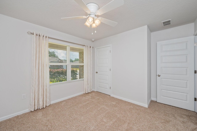 interior space featuring baseboards, light carpet, and visible vents