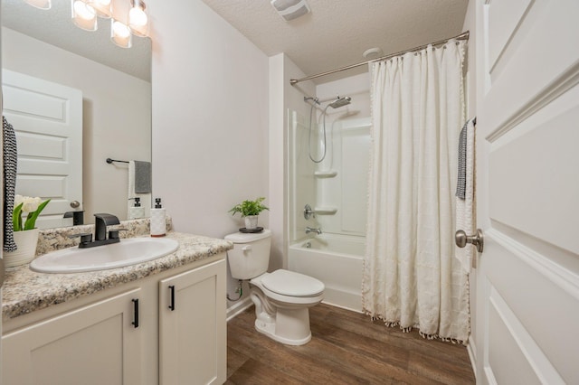full bathroom featuring a textured ceiling, wood finished floors, vanity, toilet, and shower / bath combo with shower curtain
