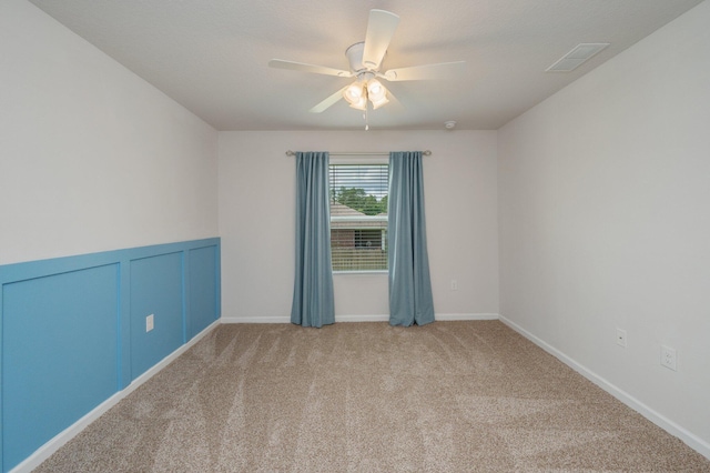unfurnished room with visible vents, carpet flooring, and ceiling fan