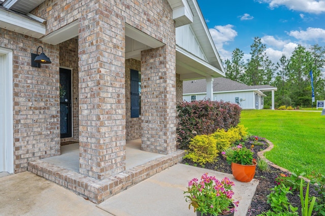 doorway to property with a lawn, a porch, and brick siding