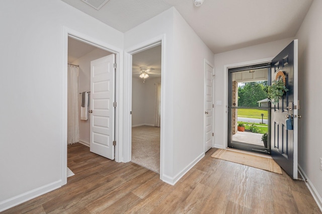 foyer featuring light wood-style floors and baseboards