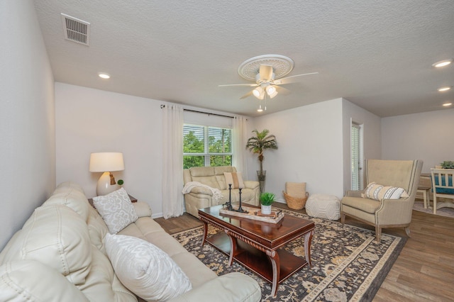 living room featuring a ceiling fan, recessed lighting, wood finished floors, and visible vents