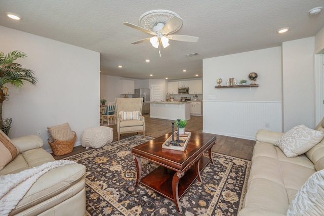living room with wainscoting, a ceiling fan, recessed lighting, wood finished floors, and visible vents