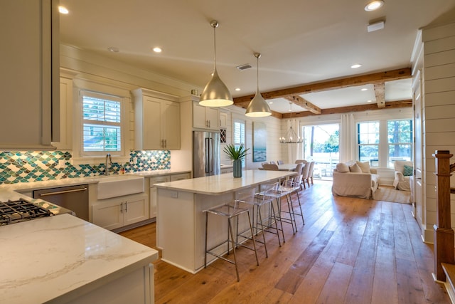 kitchen featuring high quality fridge, a healthy amount of sunlight, light wood finished floors, and open floor plan