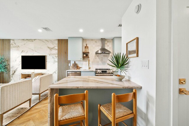 3605 E County Highway 30a Unit 236, Santa Rosa Beach, FL 32459 - kitchen with a breakfast bar area, stainless steel appliances, a sink, visible vents, and wall chimney exhaust hood