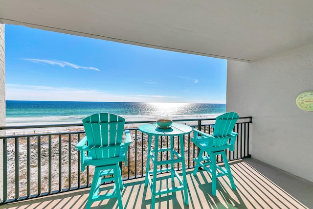 balcony with a water view and a beach view