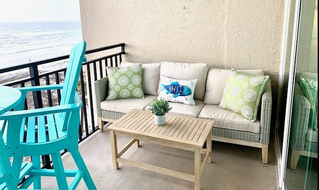 balcony with a beach view, an outdoor hangout area, and a water view