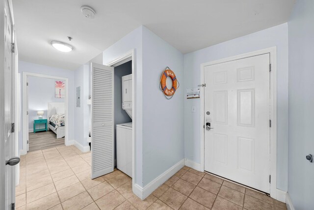 9860 S Thomas Dr Unit 501, Panama City Beach, FL 32408 - entryway featuring light tile patterned floors, baseboards, and stacked washer / drying machine