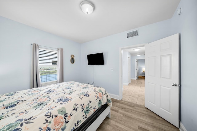 9860 S Thomas Dr Unit 501, Panama City Beach, FL 32408 - bedroom featuring baseboards, visible vents, and light wood-type flooring