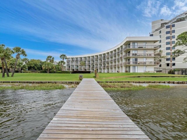 view of dock featuring a water view and a lawn