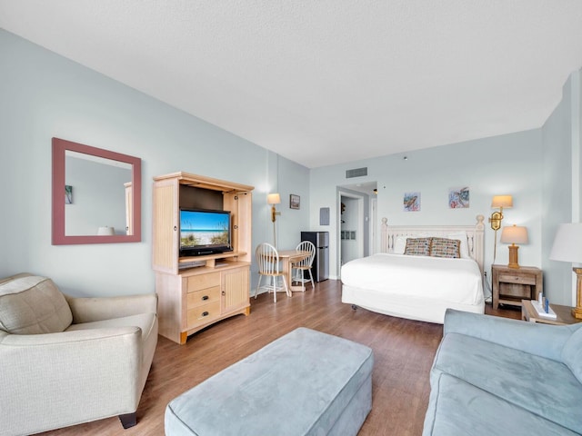 bedroom featuring visible vents and wood finished floors