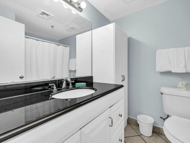full bath featuring a textured ceiling, vanity, tile patterned flooring, toilet, and baseboards