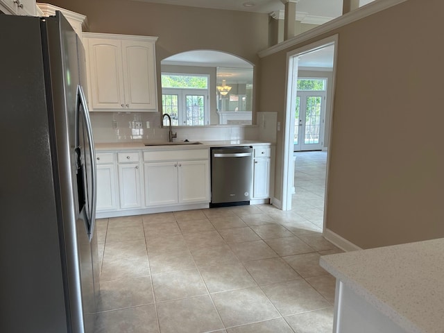 287 Stahlman Ave, Destin, FL 32541 - kitchen with appliances with stainless steel finishes, white cabinets, decorative backsplash, arched walkways, and a sink