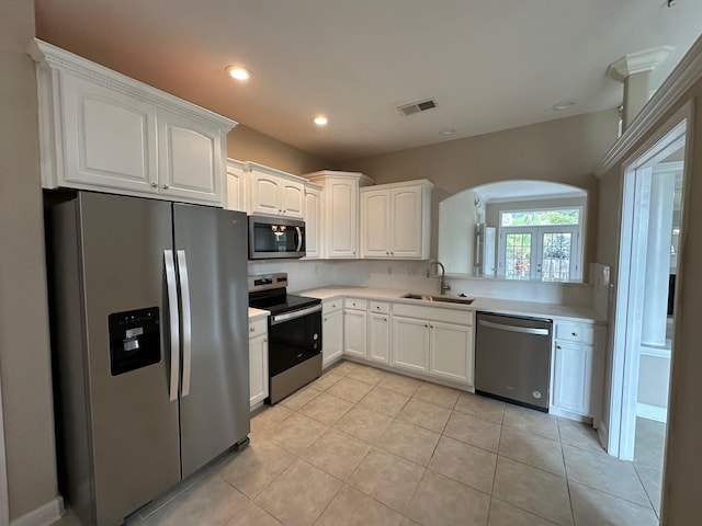 287 Stahlman Ave, Destin, FL 32541 - kitchen with visible vents, white cabinets, arched walkways, a sink, and stainless steel appliances