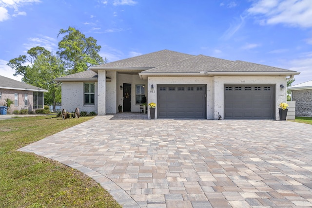 862 Bay Grove Rd, Freeport, FL 32439 - prairie-style house featuring roof with shingles, a front lawn, an attached garage, stucco siding, and decorative driveway