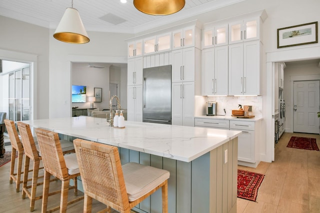 kitchen featuring stainless steel built in fridge, ornamental molding, white cabinetry, and decorative backsplash