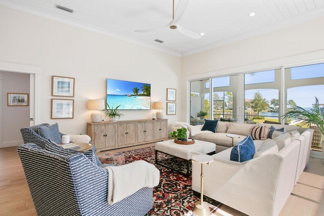 living room featuring light wood-style flooring, visible vents, a ceiling fan, and crown molding