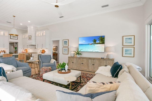 living area featuring ornamental molding and visible vents