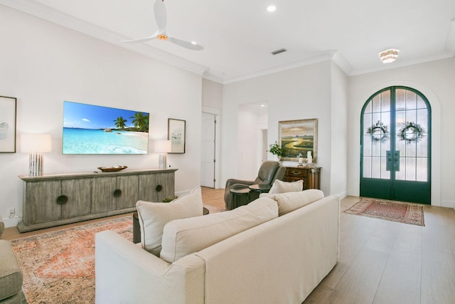 living room featuring visible vents, crown molding, wood finished floors, and french doors