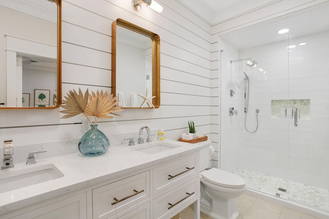 full bath featuring toilet, a sink, double vanity, and a shower stall