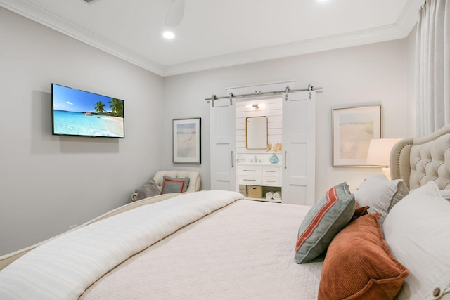 bedroom featuring a barn door, ornamental molding, ensuite bath, and recessed lighting