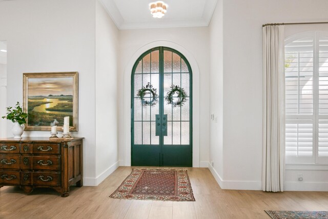 entrance foyer featuring french doors, ornamental molding, baseboards, and wood finished floors