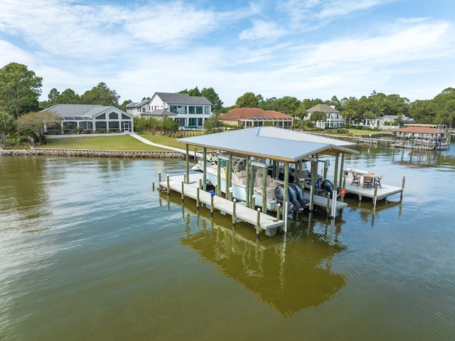 dock area with boat lift, a water view, and a yard