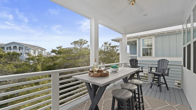 wooden terrace featuring outdoor dining space and a ceiling fan
