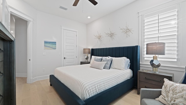 bedroom with baseboards, visible vents, ceiling fan, and light wood finished floors