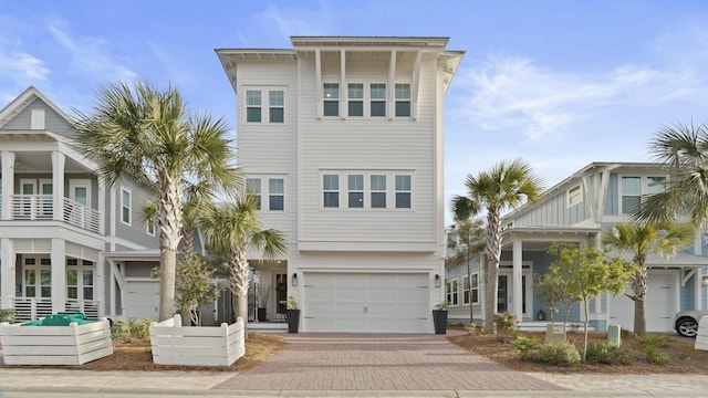 coastal home featuring decorative driveway and an attached garage