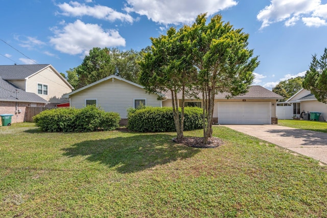 view of front facade featuring a front yard, an attached garage, fence, and driveway