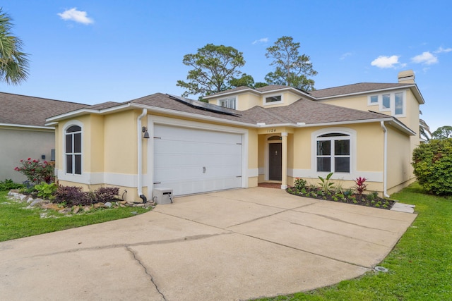 1124 Willowood Cir, Gulf Breeze, FL 32563 - traditional home featuring solar panels, an attached garage, a chimney, concrete driveway, and stucco siding