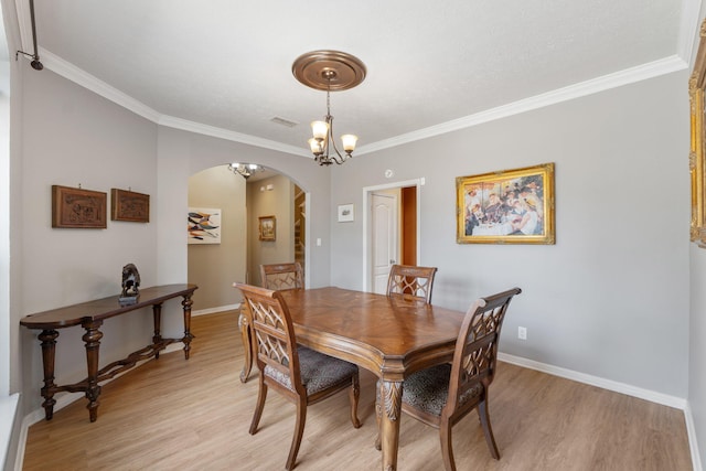 1124 Willowood Cir, Gulf Breeze, FL 32563 - dining area with arched walkways, light wood-style floors, baseboards, and ornamental molding