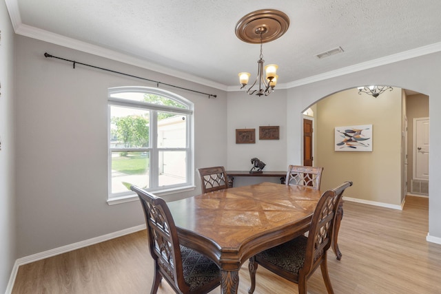 1124 Willowood Cir, Gulf Breeze, FL 32563 - dining area featuring a chandelier, arched walkways, light wood-style flooring, and visible vents