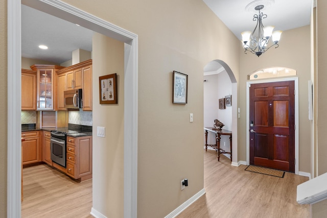 1124 Willowood Cir, Gulf Breeze, FL 32563 - foyer entrance featuring light wood-style flooring, arched walkways, a notable chandelier, and baseboards