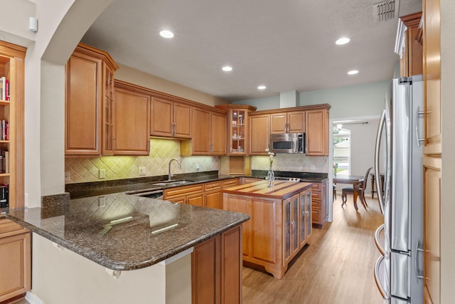 1124 Willowood Cir, Gulf Breeze, FL 32563 - kitchen with a peninsula, light wood-type flooring, a sink, stainless steel appliances, and a center island with sink