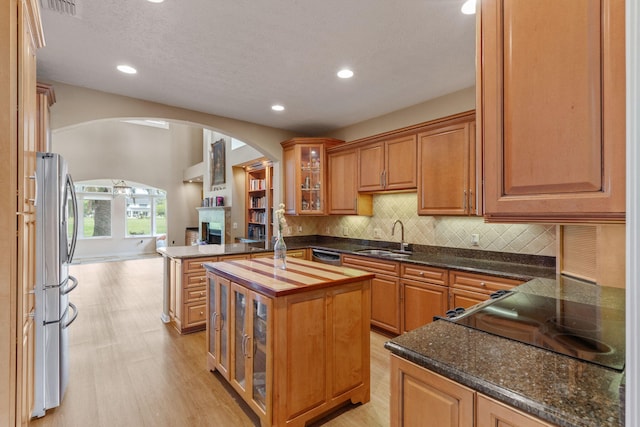 1124 Willowood Cir, Gulf Breeze, FL 32563 - kitchen featuring arched walkways, a sink, light wood-style floors, stainless steel appliances, and backsplash