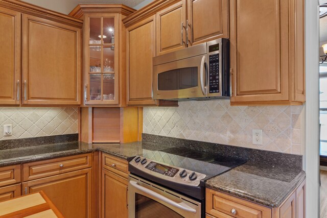 1124 Willowood Cir, Gulf Breeze, FL 32563 - kitchen with backsplash, brown cabinets, glass insert cabinets, and stainless steel appliances