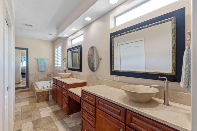 1124 Willowood Cir, Gulf Breeze, FL 32563 - full bathroom with vanity, recessed lighting, stone tile flooring, visible vents, and a garden tub
