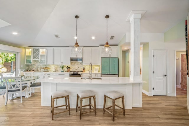 52 Secret Harbor Dr, Miramar Beach, FL 32550 - kitchen featuring stainless steel appliances, a sink, a kitchen breakfast bar, light wood-style floors, and lofted ceiling