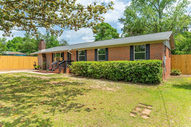 single story home featuring a chimney, a front lawn, and brick siding