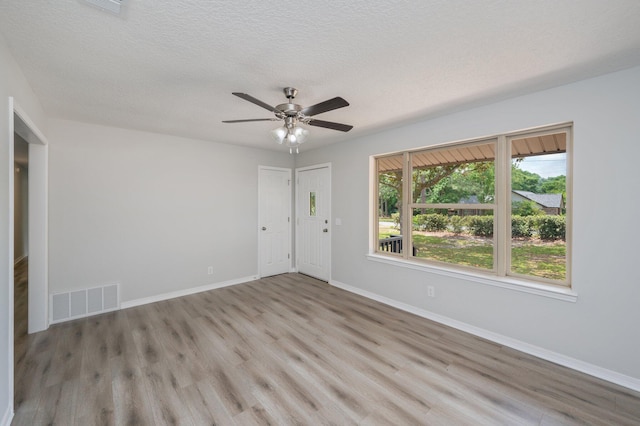 spare room with visible vents, a ceiling fan, baseboards, and light wood-type flooring