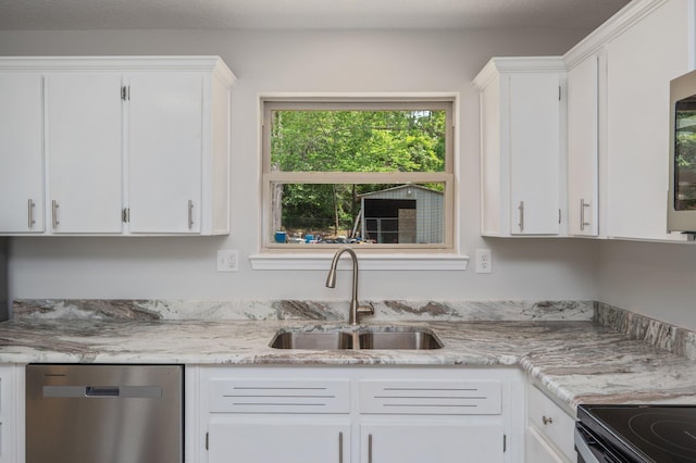 kitchen featuring stainless steel dishwasher, a sink, white cabinets, and light stone countertops